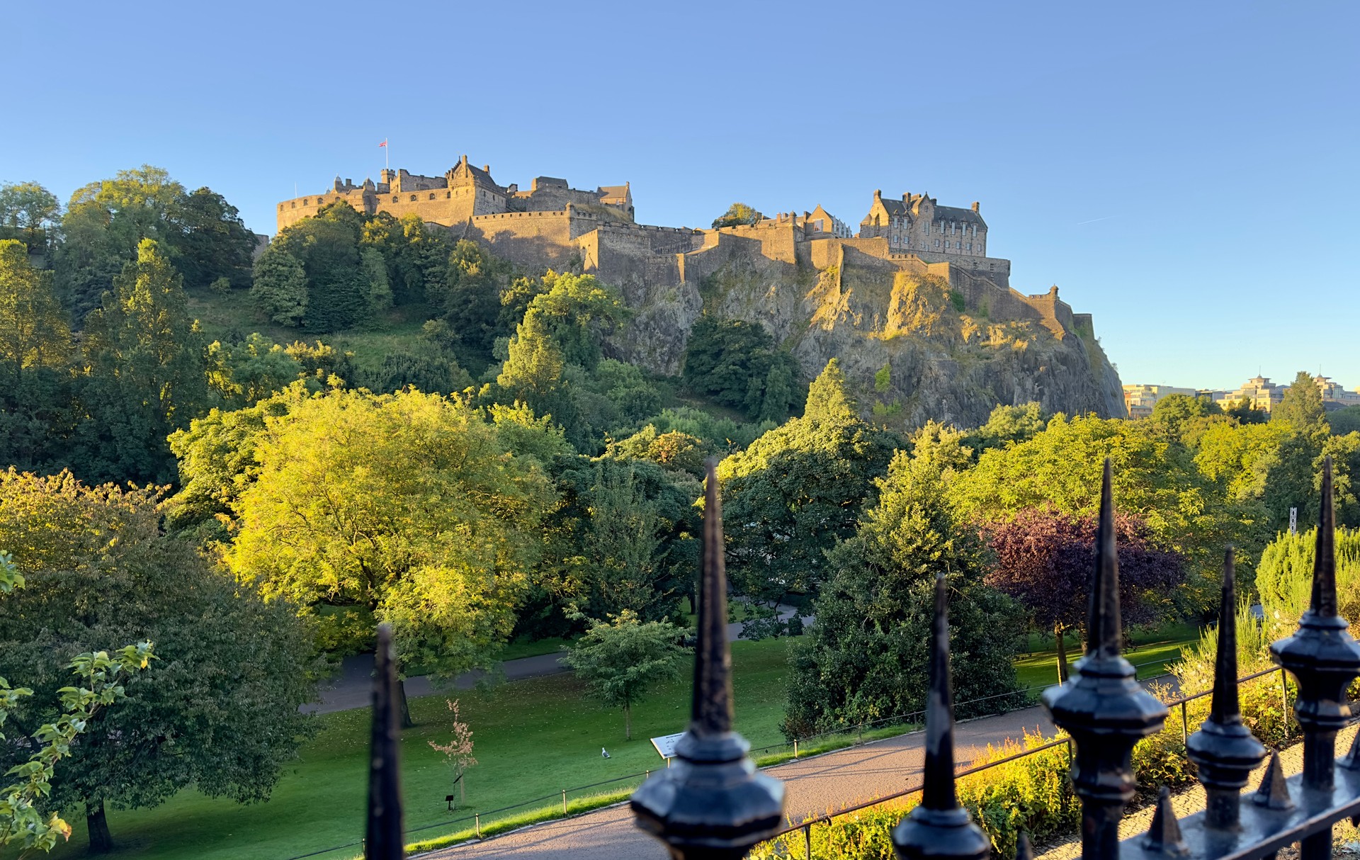 A view across Princes Street Gardens in a sunny morning with Edinburgh Castle in the distance, Scotland.