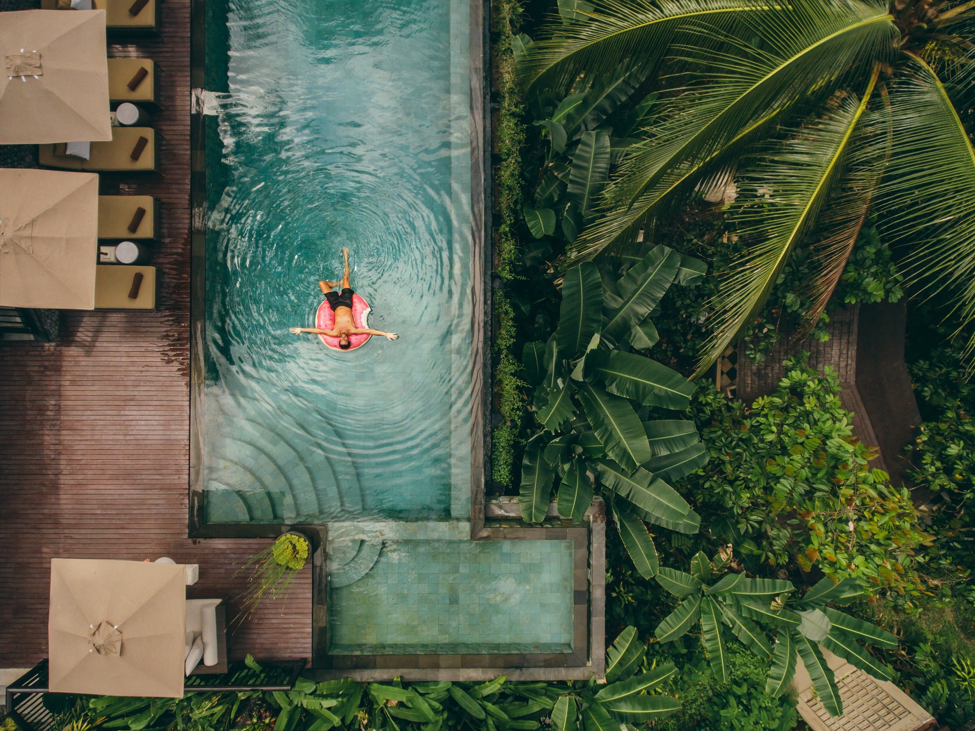 Luxury resort with man on inflatable ring in pool